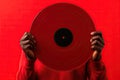 Black man hand holding old vinyl retro record. Vinyl gramophone record on red background. Royalty Free Stock Photo