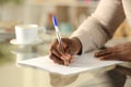 Black man hands filling out form on a desk