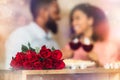 Black man having dinner with woman, focus on red roses Royalty Free Stock Photo