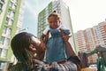 Black man hold and lift in arms joyful daughter