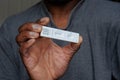 Black man holding positive Coronavirus test