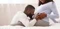 Black man hugging his pregnant wife tummy and kissing it Royalty Free Stock Photo
