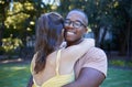 Black man, interracial relationship and hug on park lawn with love, care and bonding for quality time, reunion and Royalty Free Stock Photo