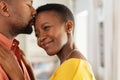 Black man kissing his wife on forehead