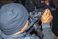 Black man with knitted cap videotaping a performance at night - shot from over his shoulder featuring camera Royalty Free Stock Photo