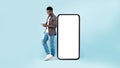 Black man leaning on white empty smartphone screen, using cellphone