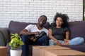 Happy african couple resting on couch with dog at home Royalty Free Stock Photo