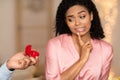 Black man making proposal with ring, confused woman rejecting Royalty Free Stock Photo