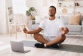 Black Man Meditating Doing Yoga Sitting At Laptop At Home Royalty Free Stock Photo