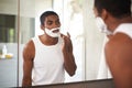 Black man, mirror and shaving cream on face in bathroom for grooming, skincare or morning routine. Reflection, beard and Royalty Free Stock Photo