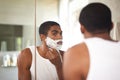 Black man, mirror and shaving with razor in bathroom for grooming, skincare or morning routine. Reflection, beard or Royalty Free Stock Photo