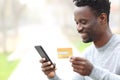 Black man paying online with credit card on phone Royalty Free Stock Photo