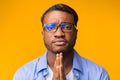 Black Man Praying Looking At Camera Standing Over Yellow Background Royalty Free Stock Photo