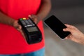 Black man in red uniform holding POS machine for payment Royalty Free Stock Photo