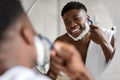 Black Man Removing Hair Shaving Face Using Razor In Bathroom Royalty Free Stock Photo