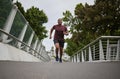 Black man running on bridge in city for fitness, exercise and healthy goals, sports wellness and marathon workout. Urban Royalty Free Stock Photo