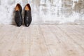 Black man`s shoes against a wall in retro interior.