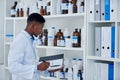 Black man, scientist and folder for stock in laboratory inventory for logistics, update and products. Doctor writing Royalty Free Stock Photo