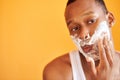 Black man with shaving foam on his face doing morning routine procedure Royalty Free Stock Photo