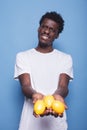 Black man showing citrus fruit to camera