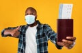 Black Man Showing Travel Tickets Gesturing Thumbs-Up Over Yellow Background Royalty Free Stock Photo