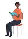 Black man sitting in school chair reading book Royalty Free Stock Photo