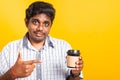 Black man smile holding coffee cup take away and pointing hand finger to coffee Royalty Free Stock Photo
