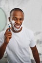 Black man, smile and shaving with blade, soap or grooming in mirror for self care in home bathroom. African guy, foam or Royalty Free Stock Photo