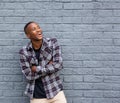 Black man smiling with arms crossed against gray wall Royalty Free Stock Photo