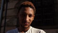 Black man smiling while looking at the camera. Portrait of a young african american man in white t-shirt on city street