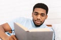 Black man studying business literature in bed Royalty Free Stock Photo