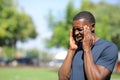 Black man suffering migraine in a park a sunny day Royalty Free Stock Photo