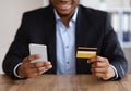 Black man in suit with mobile phone and credit card Royalty Free Stock Photo