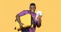 Black Man With Suitcase Showing Tickets Wearing Sunglasses, Yellow Background Royalty Free Stock Photo