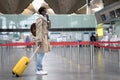 Black man with suitcase wearing face protective mask during virus epidemic, covid-19 pandemic while standing at almost empty Royalty Free Stock Photo