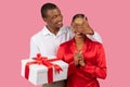 Black man surprises delighted woman with gift box