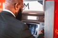 Black man taking money from an ATM