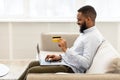 Black man using computer and credit card at home Royalty Free Stock Photo