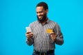 Black man using credit card and smart phone at studio Royalty Free Stock Photo