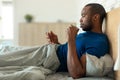Black Man Using Smartphone Drinking Coffee Lying In Modern Bedroom Royalty Free Stock Photo