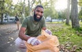 Black man, volunteer portrait and plastic bag for community park cleanup, recycling or cleaning. Ngo person outdoor in