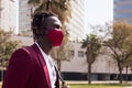 Black man walking with red mask to match his suit Royalty Free Stock Photo