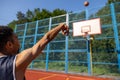 Man in wheelchair, person with disability throwing the ball into the hoop while playing basketball. Royalty Free Stock Photo