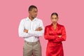 Black man and woman in serious stance, crossed arms, white and red clothes