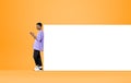 African man with smartphone near blank whiteboard on yellow back Royalty Free Stock Photo