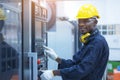 Black man working at programmable machine in factory industries