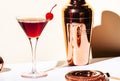 Black Manhattan alcoholic cocktail with whiskey and red vermouth garnished with maraschino cherry in martini glass. Beige Royalty Free Stock Photo