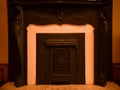 Antique fireplace covered with intricate screen