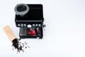 Black manual coffee maker with grinder and red coffee mug and bag of freshly roasted coffee beans on white background