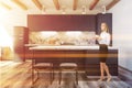 Black and marble kitchen in studio flat, woman